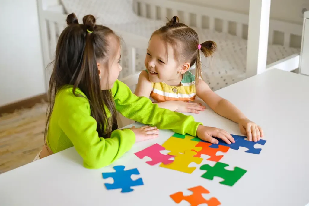 Children with autism concept, two little girls putting a puzzle together, playing together - Collinsville, IL