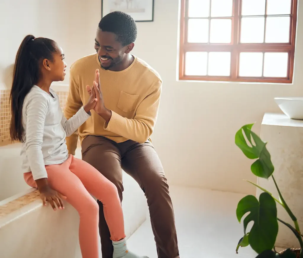 African American father celebrates with his daughter over potty training success - Collinsville, IL